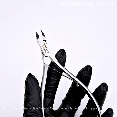 A gloved hand holds the D06 Jaw 14 Precision Cuticle Trimmer Nippers for nails, with text on a white background.