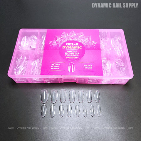 The pink box of Natural Round (Medium) Full Cover Soft-Gel Nail Tips displays 15 clear tips on a black surface.