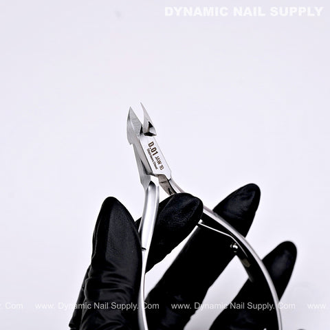 A black gloved hand holds the D01 - Jaw 16 stainless steel cuticle nippers with a precision full jaw trimmer blade.