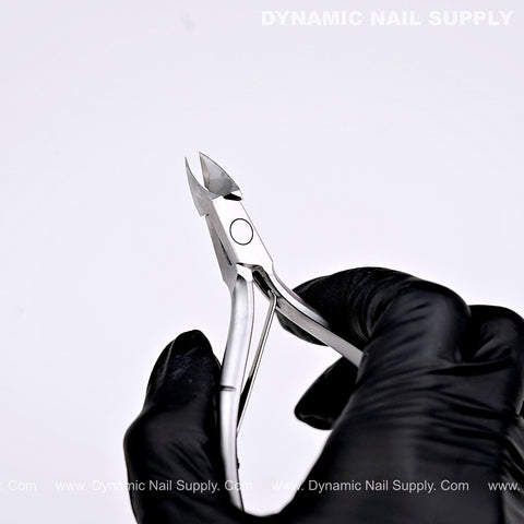 A black-gloved hand holds the D01 Jaw 16 Stainless Steel Cuticle Nippers with Precision Full Jaw Trimmer Blade.