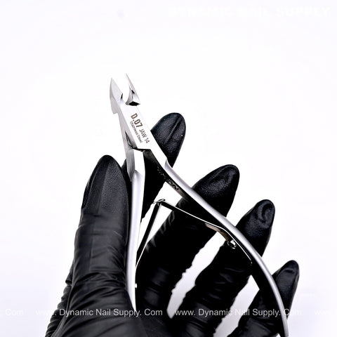 A gloved hand holds D07 - Jaw 14 Cuticle Nippers with super fine jaw and smooth spring action against a white background.