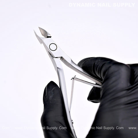 A black-gloved hand holds D07 Jaw 14 Cuticle Nippers; DYNAMIC NAIL SUPPLY text above on white background.