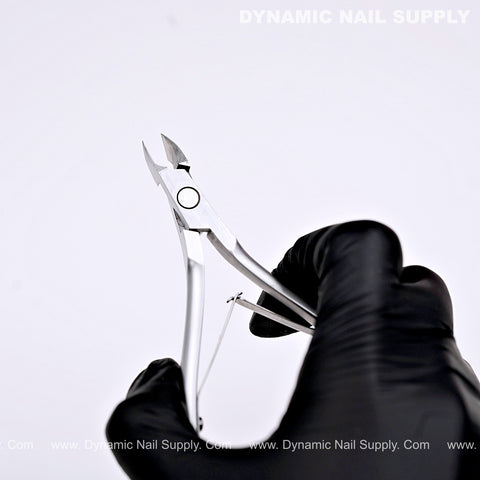 A black-gloved hand holds a D07 Jaw 14 Cuticle Nipper; text reads DYNAMIC NAIL SUPPLY on a white background.