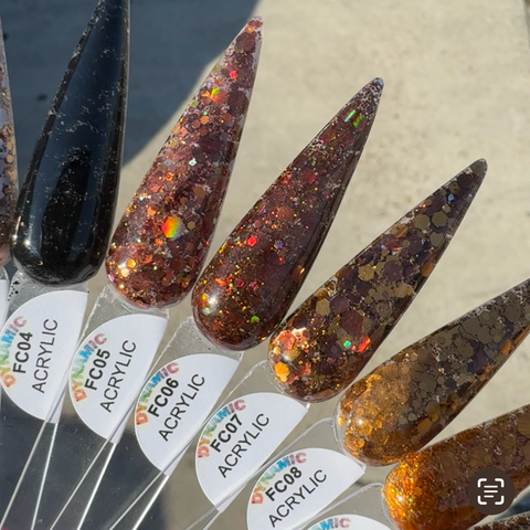 A collection of six elongated, non-toxic acrylic nail samples from Dynamic Nail Supply's "Flavors Of Fall" 2024 Acrylic Powder Collection (part 4) displays an array of colors ranging from black with subtle shimmer to glittery browns, bronzes, and golds. Each sample bears a code, FC04 to FC09, alongside the word ACRYLIC, all set against a neutral, blurred background for an elegant touch.