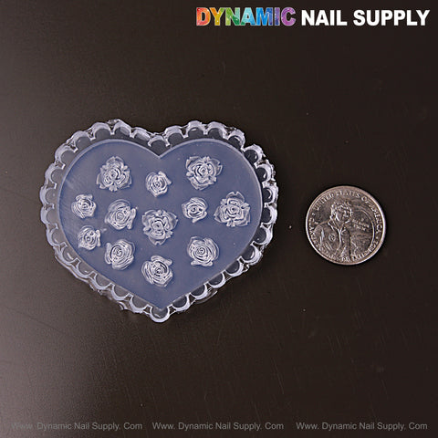 A quarter and a Mixed Size Roses 3D Nail Art Silicone Mold with raised rose designs, on a dark surface.