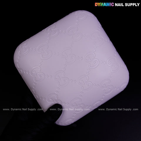 A gloved hand holds the White GC Engrave - Smooth Elbow Pad Pillow; Dynamic Nail Supply logo above.