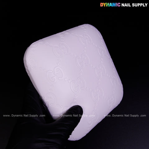 A gloved hand holds the White GC Engrave - Smooth elbow pad pillow: soft PU leather, supportive for long hours.