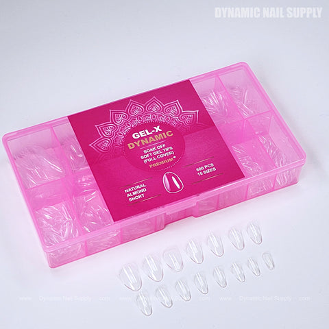 A pink box labeled Natural Almond (Short) holds clear full cover soft-gel nail tips, several displayed in front.