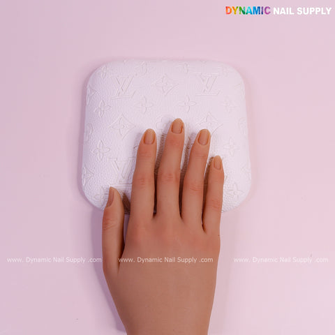 A hand rests on the (White LV Engrave - Grain) Elbow Rest Pad for Nail Tech; PU leather with embossed patterns.