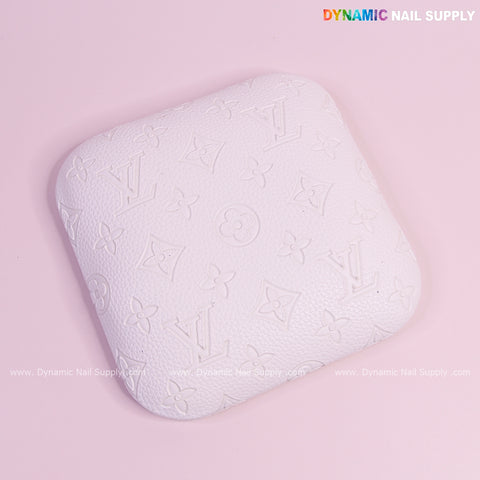 White LV Engrave-Grain elbow rest pad for nail techs, PU leather, textured with embossed Louis Vuitton patterns.