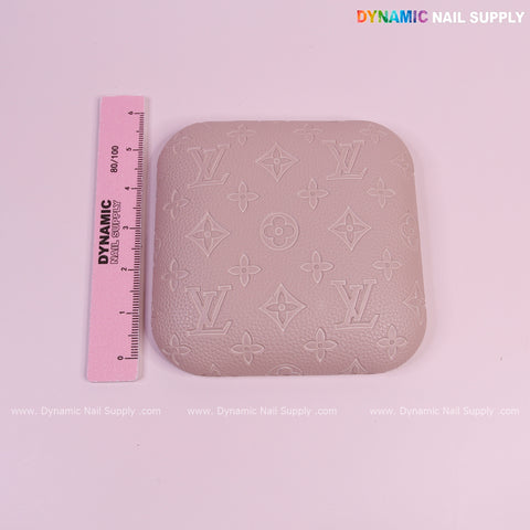 A pink ruler beside a Neutral Skin Color LV Engrave Elbow Pad Pillow for Nail Tech on a white background.