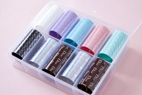 A plastic box holds 10 Nail Art Design Foils - Luxury Style on a light pink background.