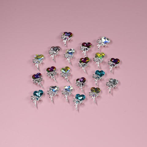 20 pcs Heart Shaped Rhinestone Charms (Heart Balloon with Bows) for nail art on a pastel pink background.