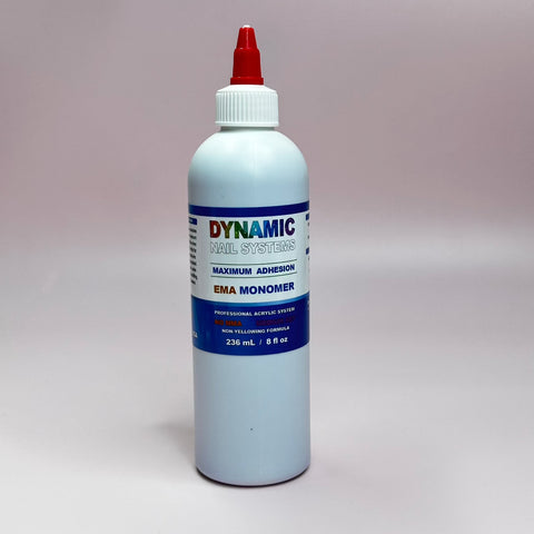 A white plastic bottle with a red spout cap displays the Dynamic Nail Supply label, featuring the Dynamic Nail System Monomer - EMA Nail Liquid. This professional-grade acrylic monomer is designed to blend seamlessly with Acrylic Powder and is enhanced with color stabilizers. The bottle holds 236 mL (8 fl oz) and is set against a plain, light gray background.