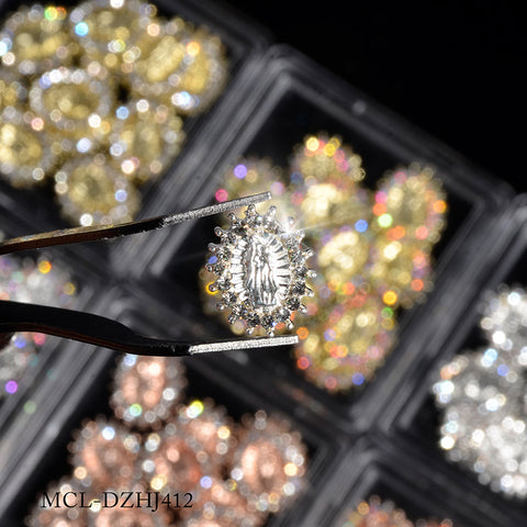 A pair of tweezers delicately grasps a detailed piece of jewelry featuring a prominent, clear central gemstone bordered by smaller glittering stones in a starburst arrangement. In the background, trays showcasing various sparkling jewelry pieces and Dynamic Nail Supply products can be seen. The text MCL-DZHJ412 is displayed at the bottom.