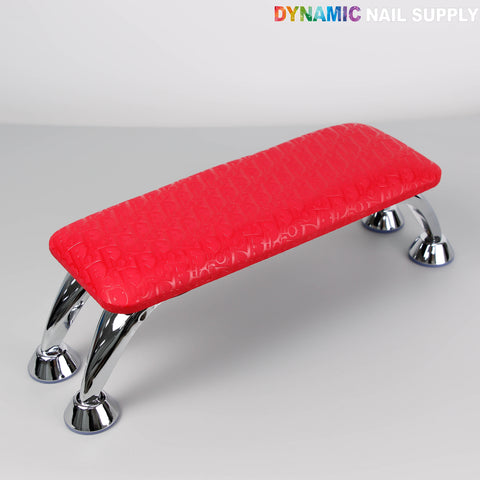 A [R-M001] Red Di0r Pattern handrest armrest for manicure, on gray surface; DYNAMIC NAIL SUPPLY shown.