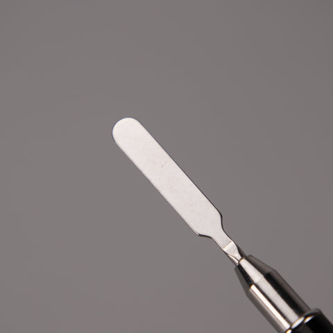 Close-up of a Black Builder Poly Hard Gel Dual Head Nail Art Brush with oval brush head and spatula on gray background.