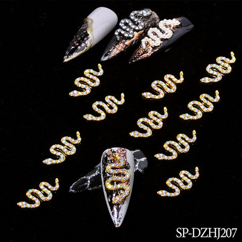 Explore the allure of snake-shaped charms in this captivating nail art design, showcasing serpentine embellishments adorned with gold and silver rhinestones on glossy black nails. One nail uniquely features a combination of black and white hues. Available from Dynamic Nail Supply under the model number SP-DZHJ207, these charms can beautifully transform your nails.