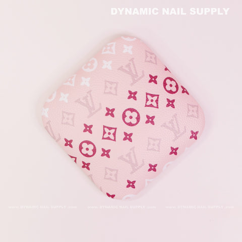 A pink, square (RA018) Elbow Armrest for Nail Technicians with red & white LV-inspired patterns on light pink.