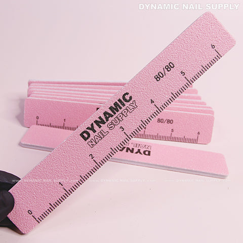 A Square Nail file 80/80 grit in pink from a 10-pack is held above a stack of acrylic nail files.