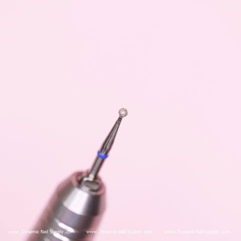 The image showcases a close-up of the Medium Cuticle Drill Bit (1.85mm diameter ball bit) by Dynamic Nail Supply, against a pink background. Ideal for cleaning the cuticle area and designed with precision for natural nail surfaces, the image features www.DynamicNailSupply.com at the bottom.
