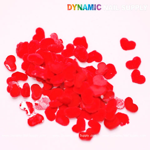 A collection of 90 Pure Red Resin Heart Shape Charms is scattered on a white surface, ideal for your Valentine Nails Design. The image features the Dynamic Nail Supply watermark, with the text in a colorful gradient.