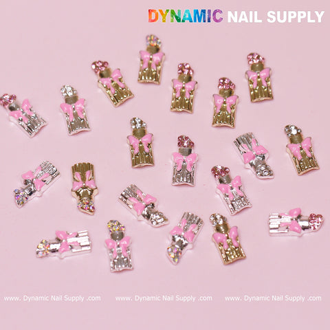 Introducing the 20 pcs Lipstick Charms with Pink Bows for Valentine's nail art design. These decorative metallic charms, adorned with rhinestone accents in pink, silver, and gold hues, create dazzling manicure styles against a pink background. Elevate your nail art with these unique embellishments from Dynamic Nail Supply.