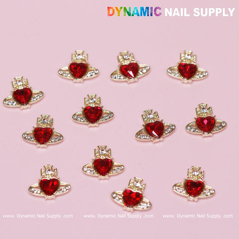 Twelve Vivienne Westwood Vintage Red Heart Charms for nail art, featuring red centers and silver accents, are displayed on a pink background. Each charm is adorned with clear, square stones. The brand name Dynamic Nail Supply is prominently displayed at the top, with the website repeated at the bottom of the image.