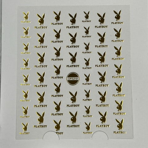 The Logo Sticker for nails art design by Dynamic Nail Supply, featuring the code DP3219, offers a sheet of small gold stickers adorned with the Playboy logo and the word "PLAYBOY" in alternating rows. These stickers are perfect for adding a touch of glamour to your nails and can be easily peeled from their plain white background.