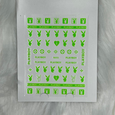 On a plush white backdrop, a sheet of Dynamic Nail Supply's Logo Sticker for Nails Art Design - Md006 - Green is displayed. The neon green decals feature iconic Playboy bunny logos, the word PLAYBOY in various font styles, along with charming small symbols like smiley faces, hearts, and stars. Ideal for effortlessly creating vibrant and playful nail art.