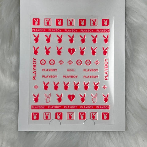 A sheet of Dynamic Nail Supply's Logo Sticker for nails art design - md006 - Red displays a variety of red designs, such as Playboy logos, bunny silhouettes, hearts, stars, and geometric shapes. This sheet is ideally suited for creative nail decoration and is elegantly showcased on a fluffy white surface.