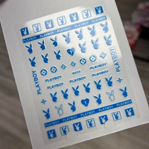 The Logo Sticker for nails art design - md006 in blue by Dynamic Nail Supply showcases an array of chic nail stickers, including the distinctive Playboy bunny logo in multiple sizes, the word PLAYBOY, and small hearts. These fashionable nail art decorations are neatly organized on a white background.