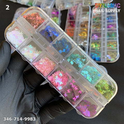 A gloved hand holds a clear organizer containing small compartments filled with colorful NAIL DESIGN GLITTERs shaped like butterflies. Each compartment houses vibrant glitter sequins in blue, pink, purple, green, and silver. The text "Dynamic Nail Supply" along with a phone number is displayed.