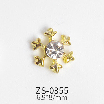 A small, gold snowflake-shaped charm adorned with a clear, round gemstone in the center. It features six decorative branches and is perfect for enhancing nail shapes. The text below reads ZS-0355 and 6.9*8/mm on a white background—a stunning addition from Dynamic Nail Supply's 24pcs Snowflake Charms for Winter and Christmas nails art design collection.