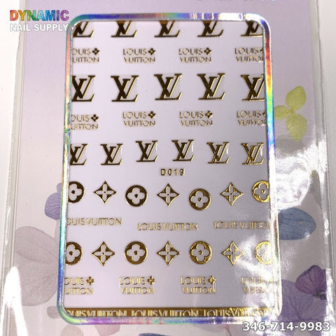 A holographic card proudly showcases the NAIL ART DESIGN STICKER - D019, featuring exquisite gold nail art decals with Louis Vuitton logos, including LV initials and floral motifs. Set against a white backdrop, Dynamic Nail Supply and a contact number complete the elegant presentation.