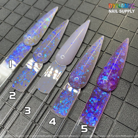 Five transparent nail tips, each featuring a distinct iridescent design from the Explicit series - Dirty Sprite - Glitter Acrylic Powder Collection for sculpting and dipping nails, are arranged on a grid surface. Numbered 1 to 5, the colors range from light blue and lavender to deep purple. In the top right corner, "Dynamic Nail Supply" is displayed in colorful text.