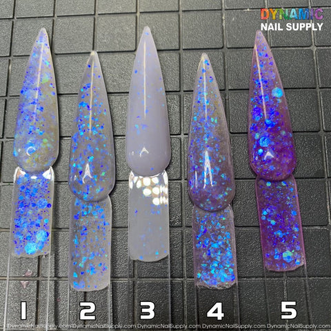 Five nail samples featuring glittery blue and violet hues from the Explicit series - Dirty Sprite - Glitter Acrylic Powder Collection are displayed on a textured black surface. The shades vary: gray with blue speckles (1, 2), gray with holographic glitter (3), and purple with blue glitter (4, 5). Ideal for sculpting nails, the Dynamic Nail Supply logo is located in the top right corner.