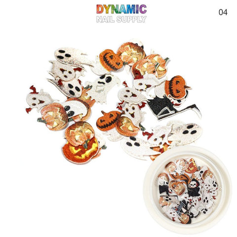 Introducing the Halloween Sequins for Nail Art Design by Dynamic Nail Supply: a spooky collection of ghost and pumpkin-themed decals, enhanced with delicate sequins for added sparkle. Displayed on a white background, these decals offer a variety of styles and expressions in vivid orange, black, and white hues. Complementing the set is a small dish in the lower right corner, containing additional decals.