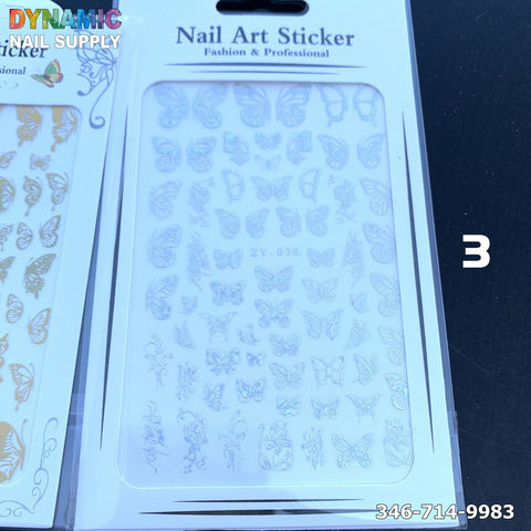 A sheet of nail art stickers adorned with holographic designs of white butterflies and flowers is showcased against a dark background. The sticker pack, titled Holographic Metallic Butterfly Sticker for Nail Art Design, prominently displays the Dynamic Nail Supply logo along with a contact number.