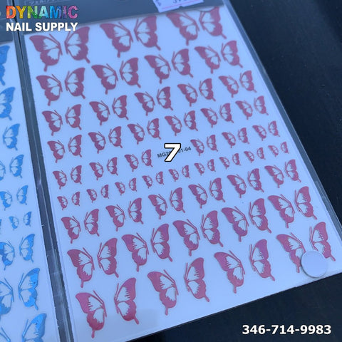 A sheet of holographic metallic butterfly stickers for nail art design is displayed on a dark surface. The butterflies vary in size and are neatly arranged in rows. The top left corner features "Dynamic Nail Supply" in multicolored text, while the bottom right corner shows the phone number 346-714-9983.