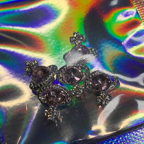 A set of five exquisitely crafted Planet Charms for nail art, featuring pink rhinestones, from Dynamic Nail Supply. These charms are designed with intricate silver-tone details and small star accents that shimmer on a reflective surface, creating a vibrant iridescent swirl of colors such as green, blue, and orange.