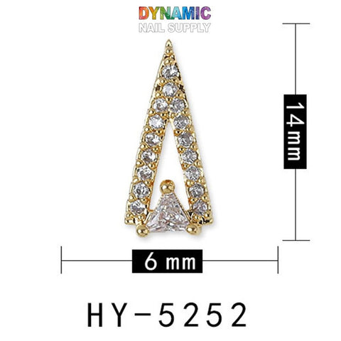 The Luxurious Jewelry for Nail Art design from Dynamic Nail Supply showcases sophistication with its gold triangular craftsmanship adorned with small white gems and a prominent triangular gem at the base. Measuring 14mm by 6mm, model HY-5252 exudes elegance. The Dynamic Nail Supply logo is prominently featured in vibrant text at the top.