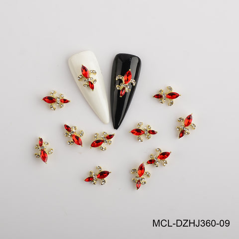 Saint Fleur De Lis charms in red and gold surround black and white nail tips on a plain white background.