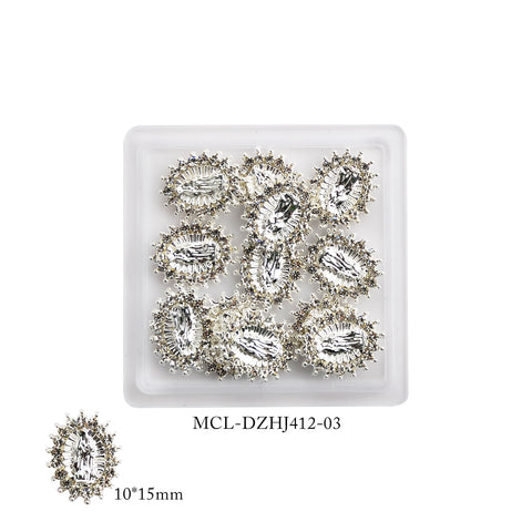 A small plastic tray showcases twelve oval-shaped, clear gemstones with intricate silver settings, reminiscent of refined religious nail designs. Below the tray, a close-up highlights the exquisite details of these 10x15mm gems. The code MCL-DZHJ412-03 is associated with them, assuring a quality similar to that offered by Dynamic Nail Supply's Virgin Mary charms for religious nail art.