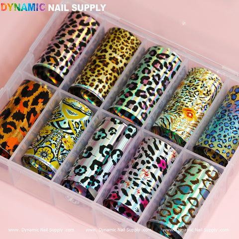 A clear plastic organizer from Dynamic Nail Supply holds ten rolls of their Nail Art Design Foils - Animal Skin, showcasing vibrant patterns like leopard and cheetah. Each roll features playful colors such as orange, teal, pink, and gold, offering a variety of styles for creative nail decoration.