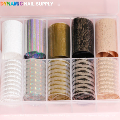 A clear plastic container from Dynamic Nail Supply holds rolls of decorative design foils, making it ideal for nail art enthusiasts. The top row features foils in white, iridescent, gold, black with patterns, and beige. The bottom row includes the Nail Art Design Foils - Letters Style in white, as well as holographic effects, gold patterns, black and white stripes, and tan prints.