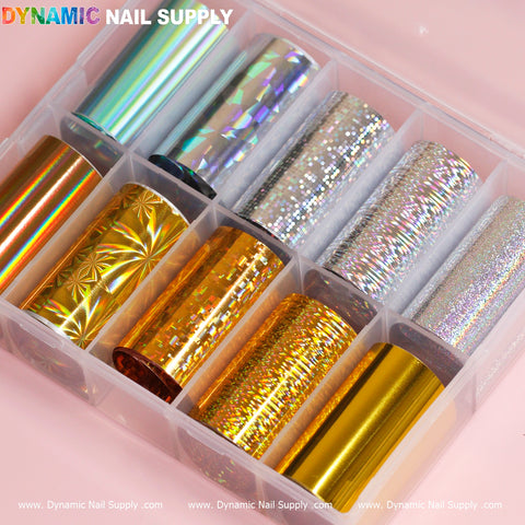 A plastic organizer presenting the "Nail Art Design Foils - Gold/Silver Holographic" from Dynamic Nail Supply, featuring ten rolls of vibrant nail art foils. The top row impresses with silver and holographic motifs, and the bottom row captivates with gold and orange tones, incorporating geometric and reflective designs ideal for holographic nail art enthusiasts.