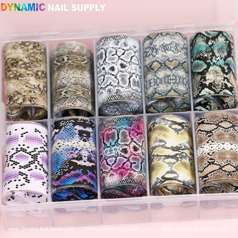 The "Nail Art Design Foils - Animal Skin Style" by Dynamic Nail Supply feature an assortment of animal skin designs, including snake and leopard patterns, in a variety of color combinations. These design foils come neatly arranged in a clear plastic organizer with twelve compartments, each showcasing a unique pattern. The Dynamic Nail Supply logo is prominently displayed at the top.