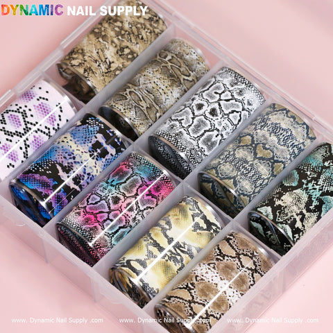 A transparent container featuring ten sections houses rolls of Nail Art Design Foils - Animal Skin Style, displaying snake skin patterns in black, white, brown, and multicolored designs. Ideal for nail art enthusiasts, the soft pink label displays the brand name Dynamic Nail Supply.