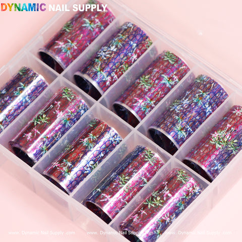 A plastic organizer from Dynamic Nail Supply houses nine rolls of Nail Art Design Foils - Luxury Style, featuring floral and abstract designs in a blend of pink, blue, purple, and green hues. The foils are neatly arranged in individual compartments.